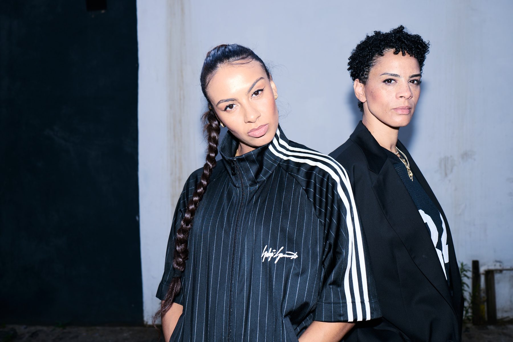 Mel and Holly photographed at night in black tracksuits
